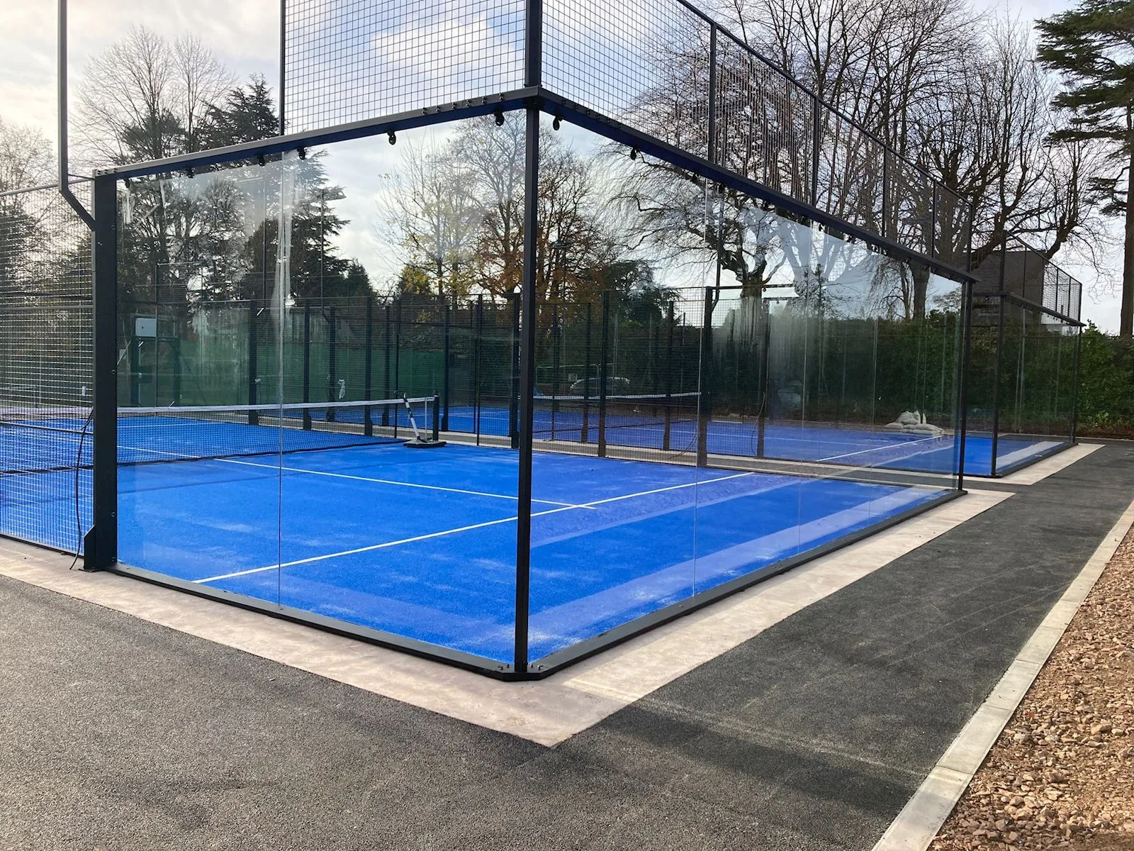 Glass-walled padel courts at Four Oaks Tennis & Padel Club