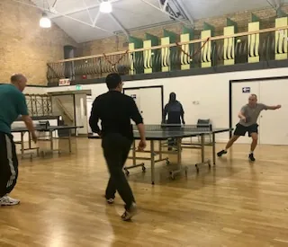 Adults playing table tennis in the main hall at Stirchley Baths