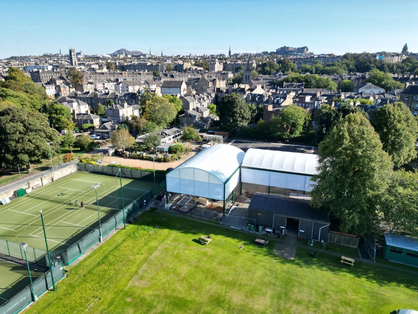 Building photo: aerial view of The Grange Club with its covered courts