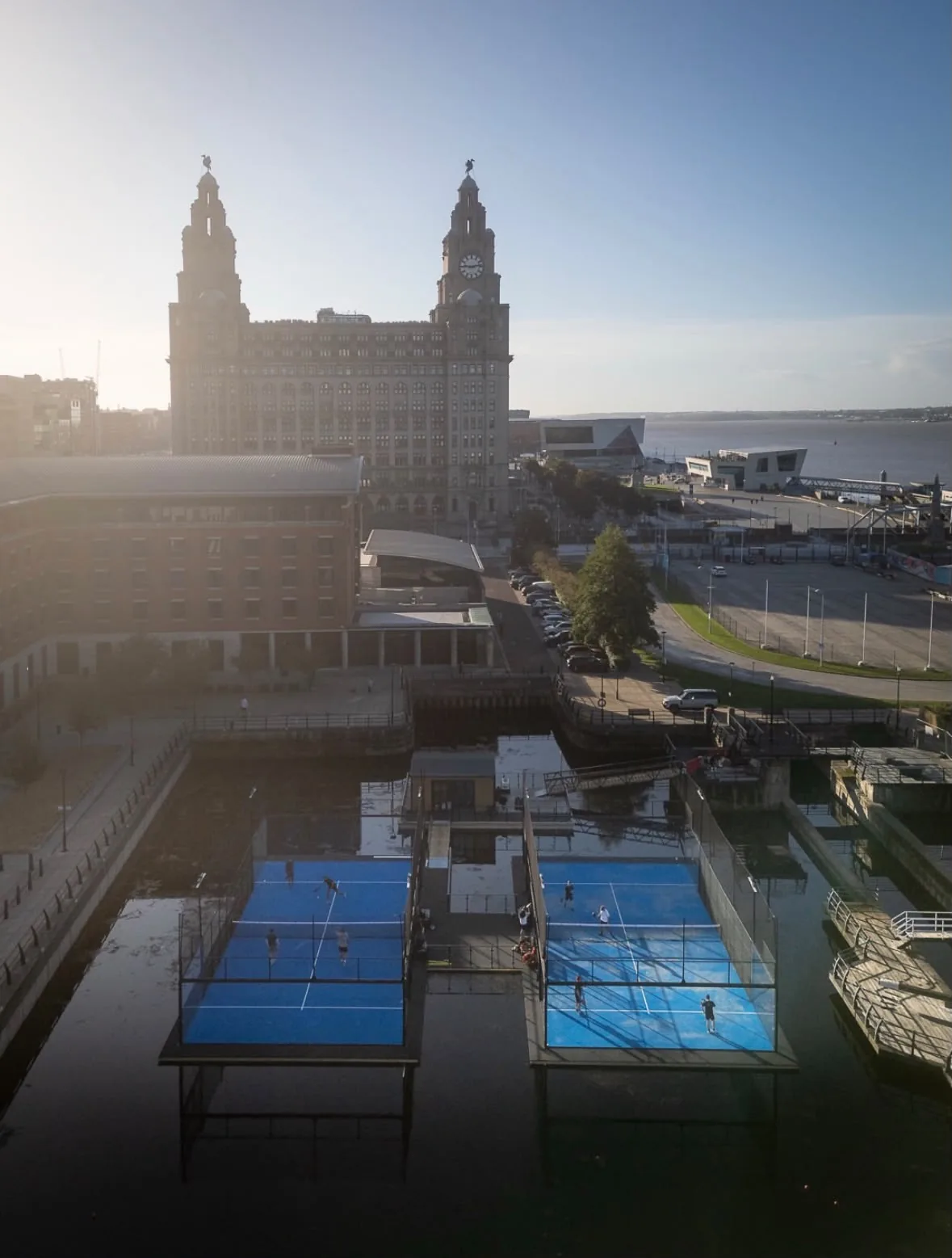 The two floating padel courts at Vibora on Princes Dock, with the Royal Liver Building behind