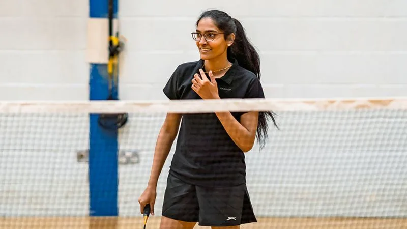 Badminton player at the net in the Oxford Brookes Sports Hall